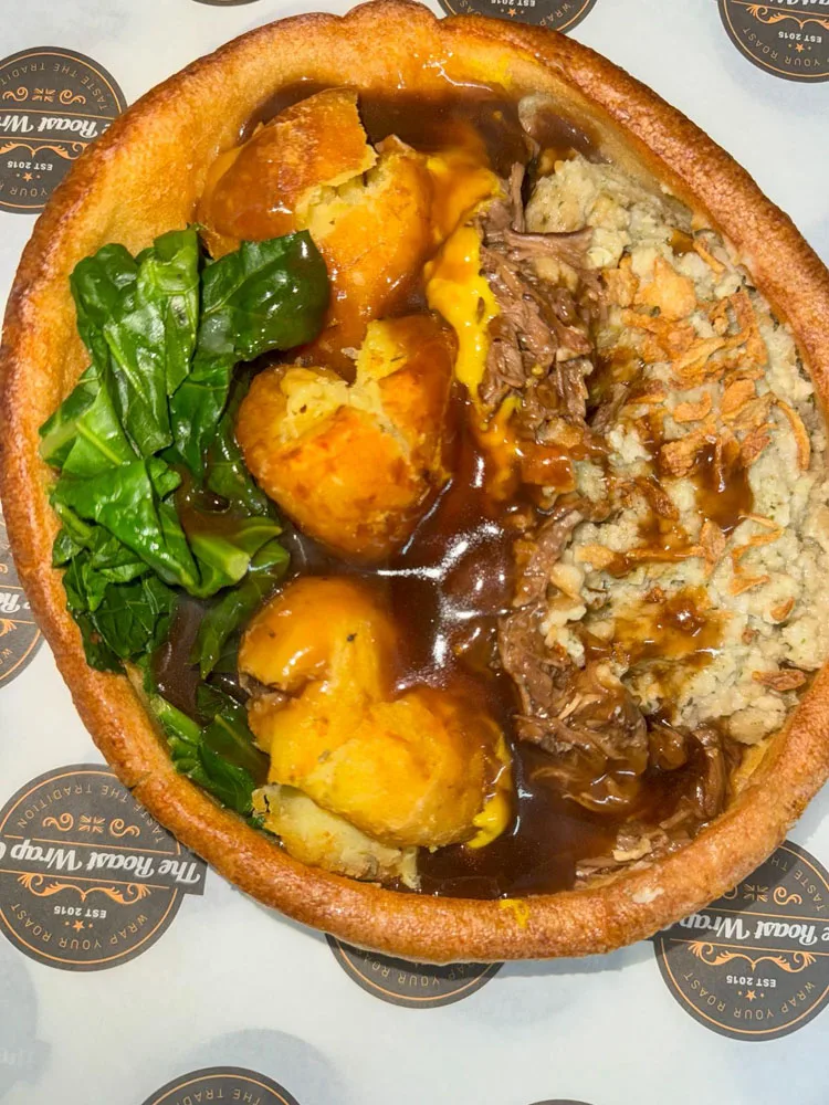 An open Yorkshire pudding filled with roast beef, vegetables, potatoes and gravy