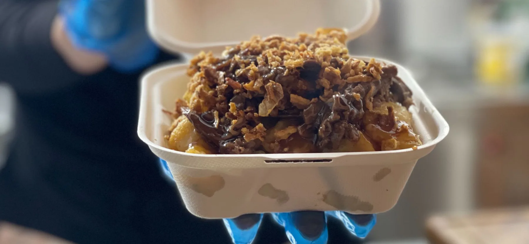 A loaded roast box with potatoes, beef, gravy and crispy onions
